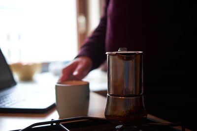 Midsection of coffee cup on table