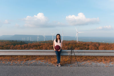 Woman standing on road against sky