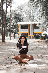 Portrait of smiling woman sitting on snow