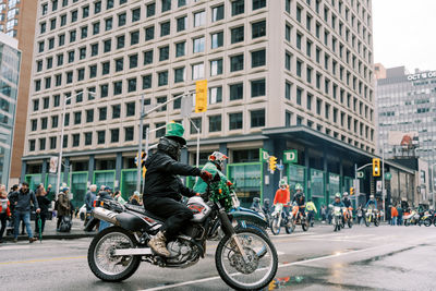 Side view of man riding motorcycle on street in city