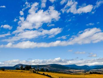 Scenic view of landscape and mountains against blue sky