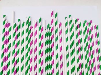 Close-up of multi colored umbrellas hanging on white background