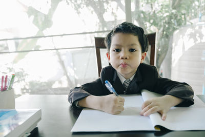 Portrait of boy sitting on table