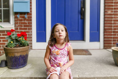 Full length of girl sitting outdoors