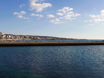 Scenic view of sea by city against sky