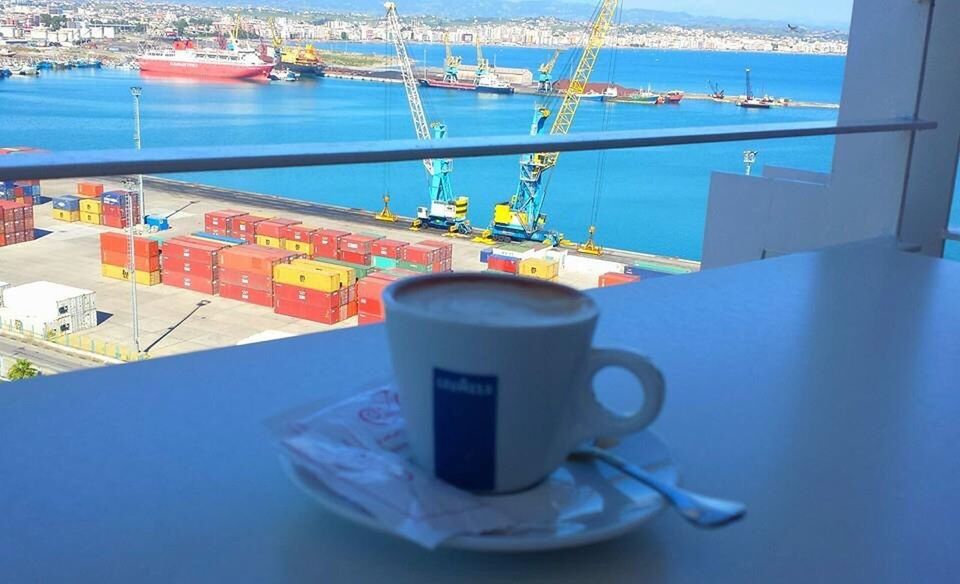 CLOSE-UP OF COFFEE ON TABLE AGAINST SEA