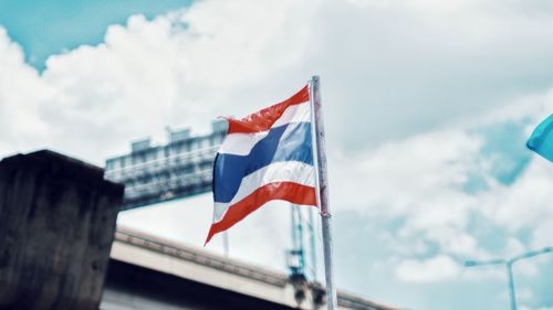 Low angle view of flag against cloudy sky