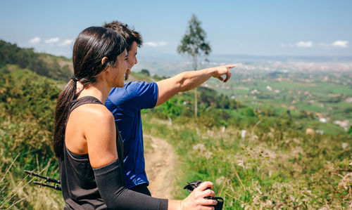 Couple looking at landscape while standing on mountain