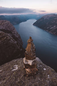 Stack of rocks by sea against sky