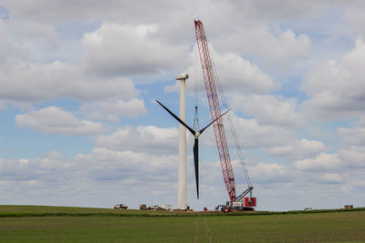 Traditional windmill on field against sky