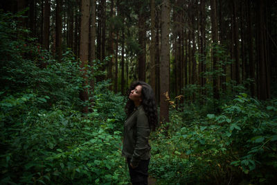 Young woman standing in forest