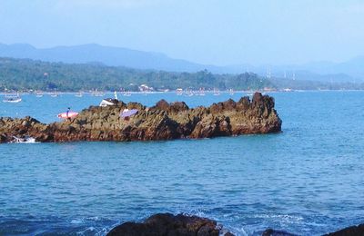 Scenic view of sea and mountains against clear sky