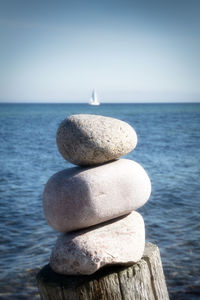 Stack of stones by sea against sky