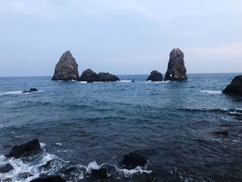 Rocks in sea against sky