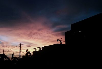 Low angle view of silhouette built structure against sky at sunset