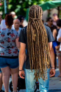 Rear view of man with long dreadlocks on street