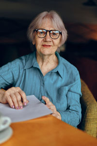 Portrait of young woman reading book at home