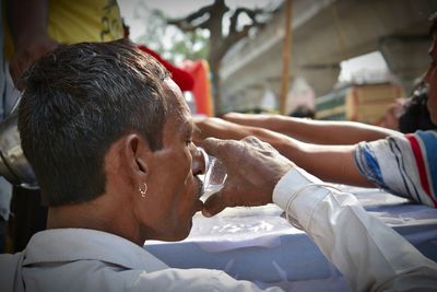 Close-up of man drinking water outdoors