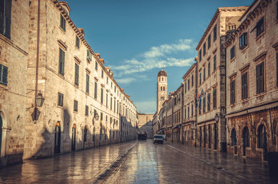 Street amidst buildings against sky in city