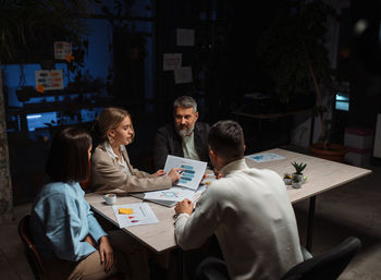 Business discussion in contemporary evening office of team