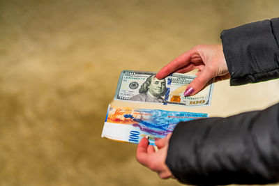 Cropped hands of woman holding paper currency