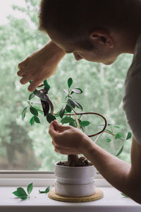 Man cutting plant at home