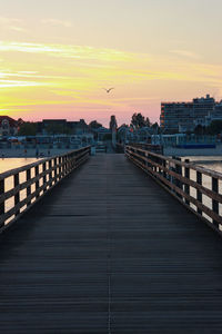 Bridge over sea against sky during sunset