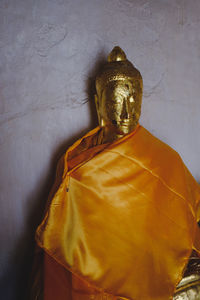 Statue of buddha against wall