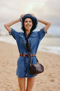 Portrait of young woman standing at beach