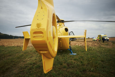 Helicopter of emergency medical service landing on field next to road. 