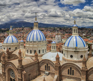 Buildings in city against cloudy sky