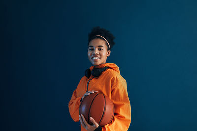 Portrait of young man standing against blue background