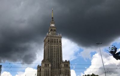 Low angle view of buildings against cloudy sky