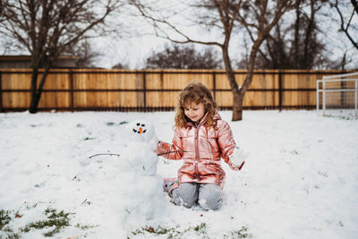 Girl standing on snow covered tree