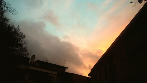 Low angle view of silhouette buildings against sky