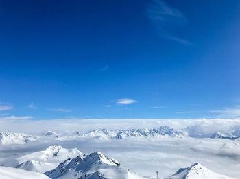 Scenic view of snowcapped mountains against blue sky