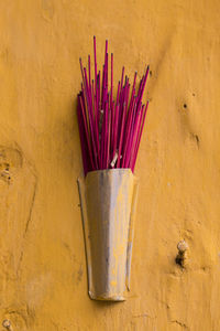 Close-up of sticks in container on wall