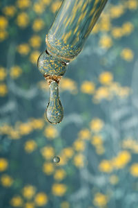 A dripping pipette with a drop of cosmetics gel.