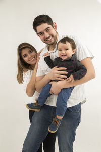 Portrait of happy friends standing against white background