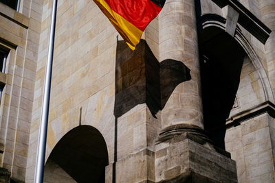 Low angle view of german flag waving against building