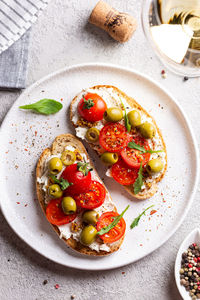 Bruschettas with olives and fresh tomatoes and wineglass