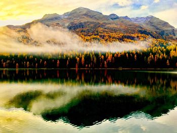 Scenic view of lake by mountain against sky