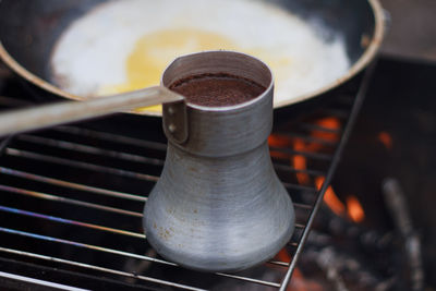 Close-up of ladle over grill