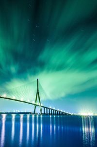 Low angle view of suspension bridge against sky at night