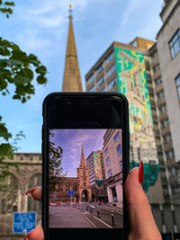 Cropped hand of woman using mobile phone