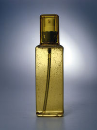 Close-up of perfume bottle on blue background