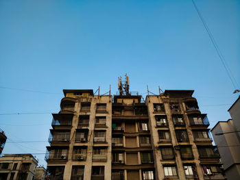 Low angle view of buildings against clear blue sky