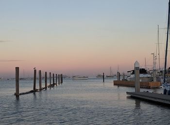 Pier on sea against sky during sunset