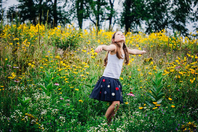 Girl with arms outstretched standing on field