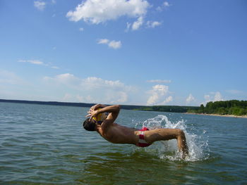 Man surfing in sea against sky